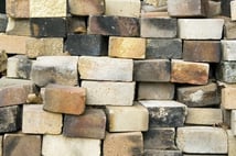 Bricks of various colors and conditions in a stack