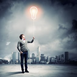 Young man holding a light at his hands against polluted and ruined landscape