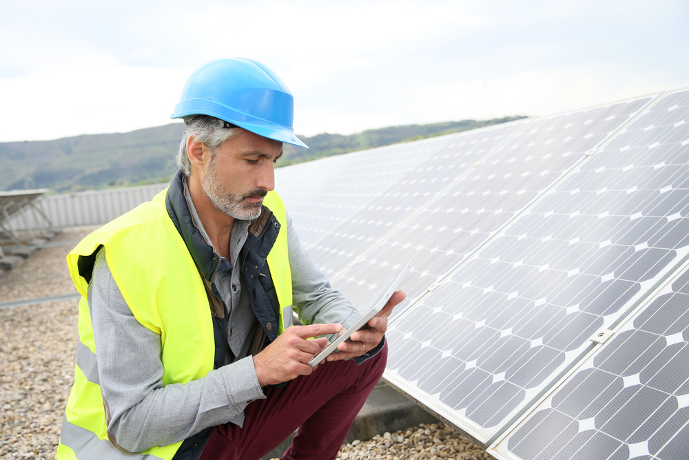 Engineer on building roof checking solar panels