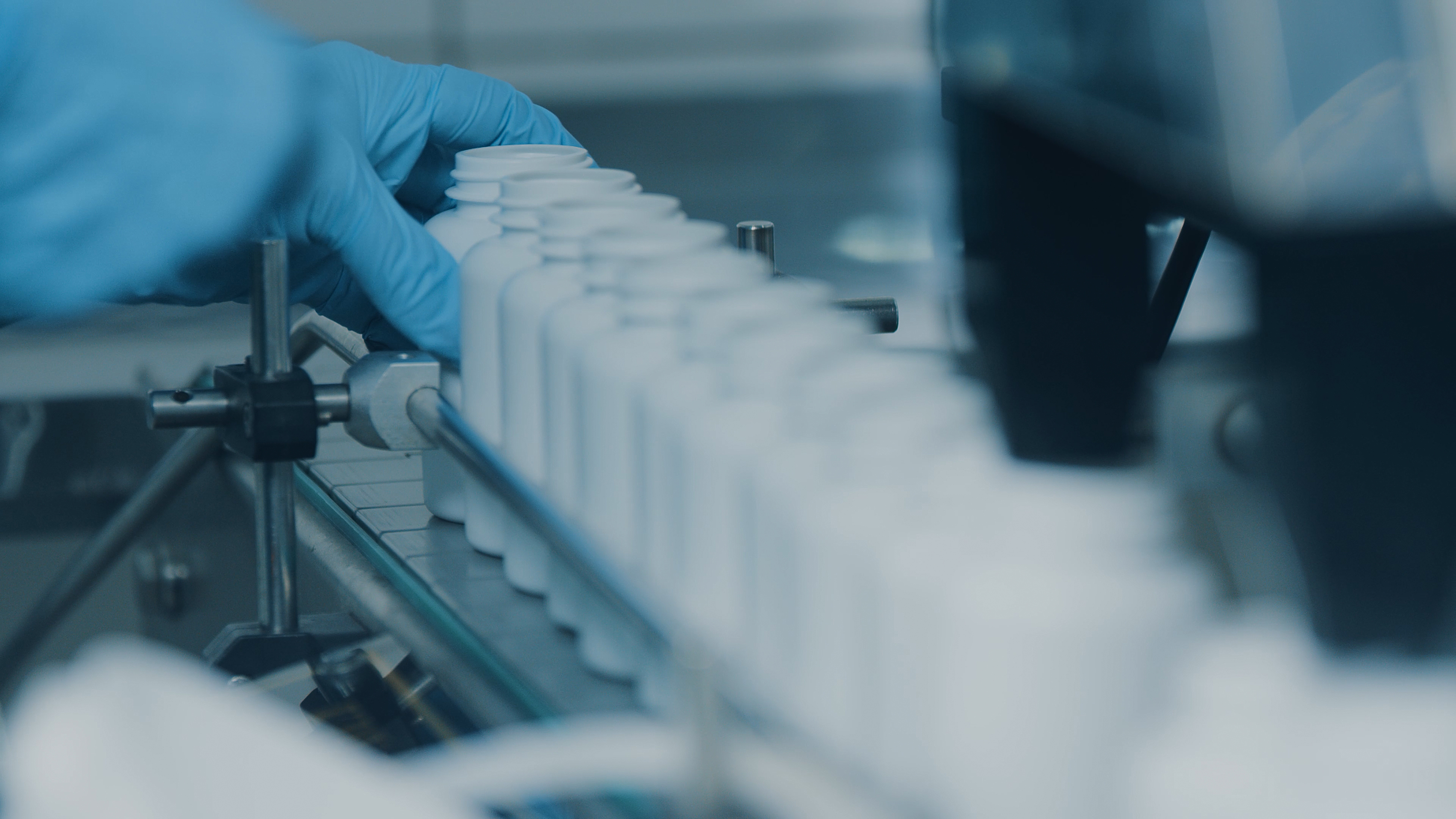 Conveyor with moving empty white plastic tubes on the production line